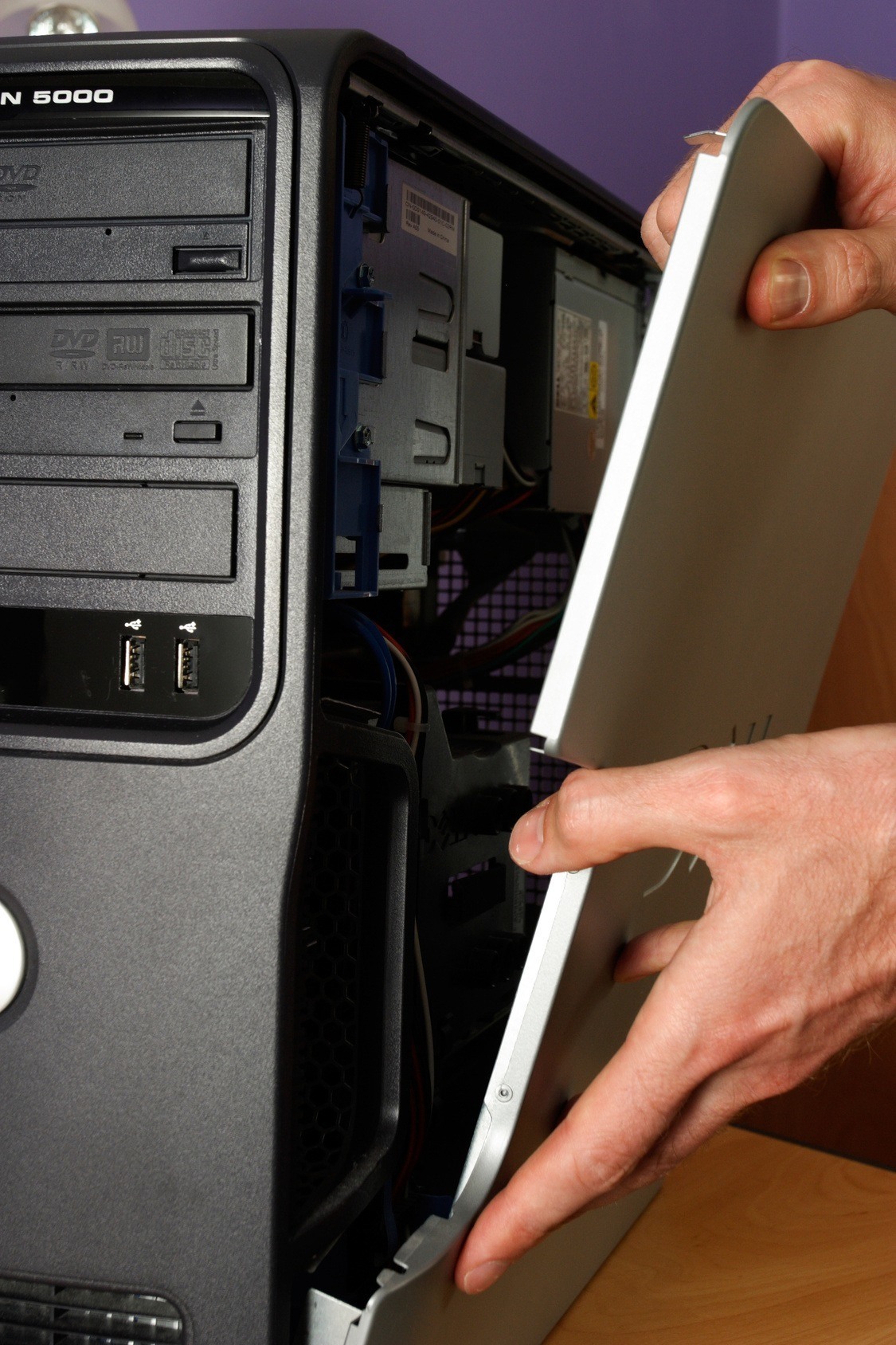 close-up of a black in 5000 tower being upgraded, showcasing internal components and cables.
