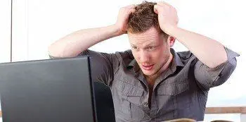 Disaster Recovery: Most Common Causes Of Data Loss 4 young man stressed at computer, showing the emotional toll of digital work challenges.