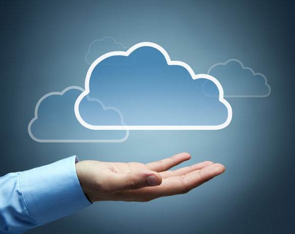 human hand cradling cloud symbolizing cloud computing against a serene blue backdrop.