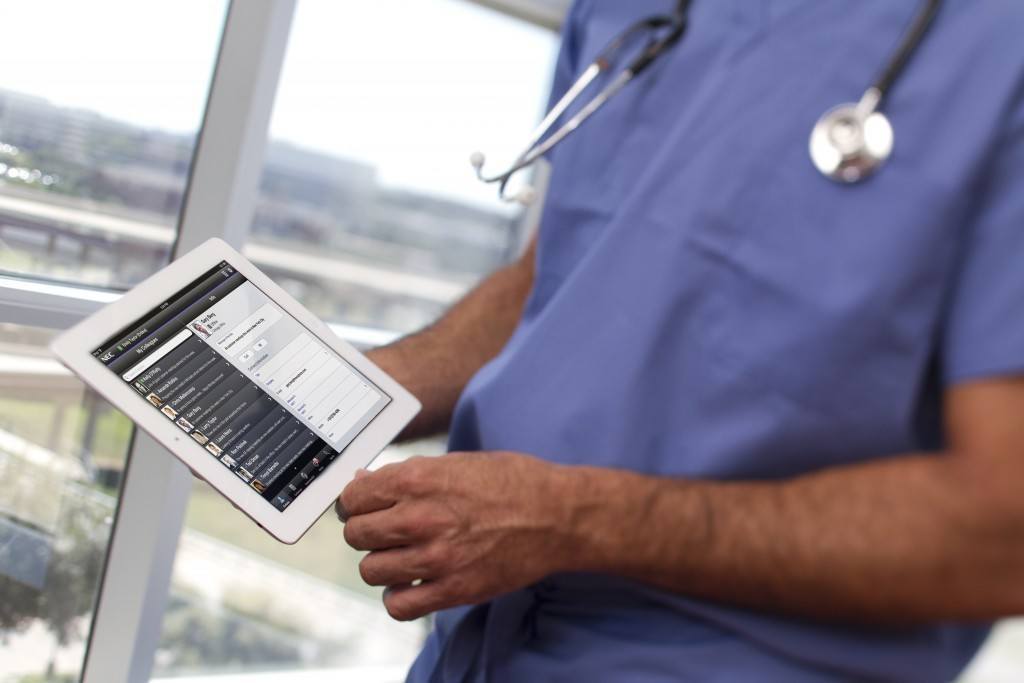healthcare professional using a tablet to manage patient data in a modern medical setting.