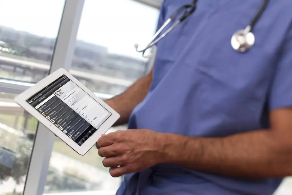 healthcare professional using a tablet to manage patient data in a modern medical setting.