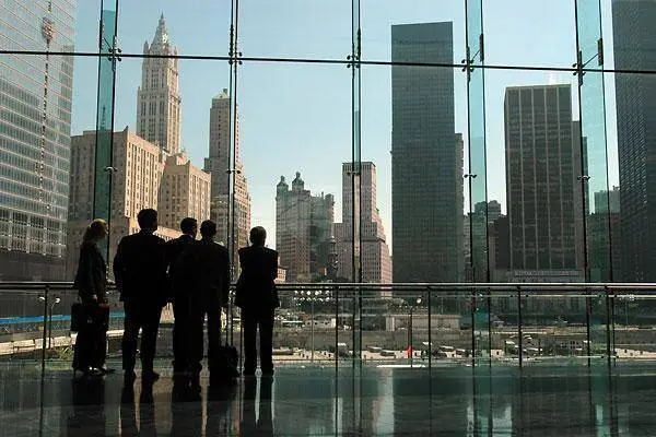 five business professionals reflect on city life while observing a dynamic urban skyline.
