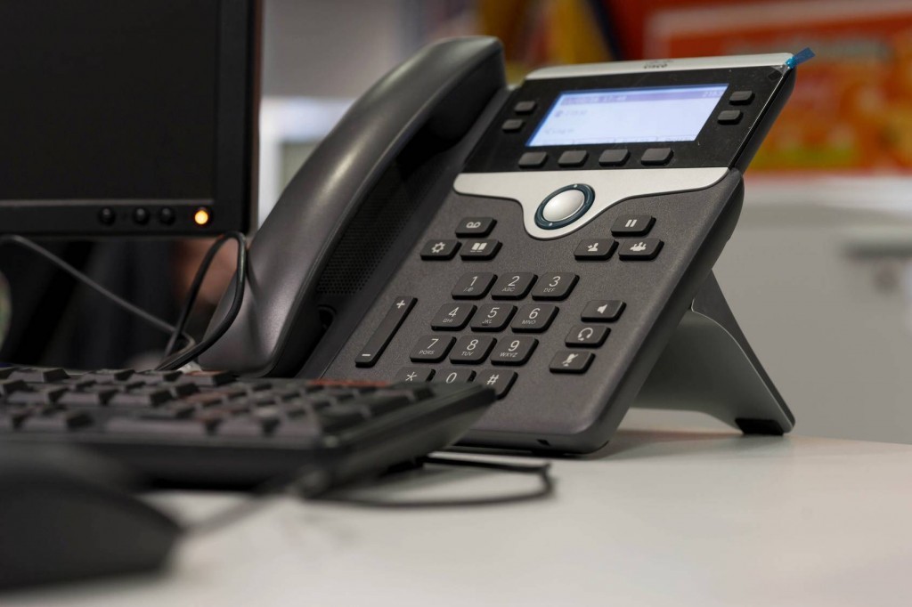 modern office setup featuring a professional telephone and a frequently used keyboard for productivity.