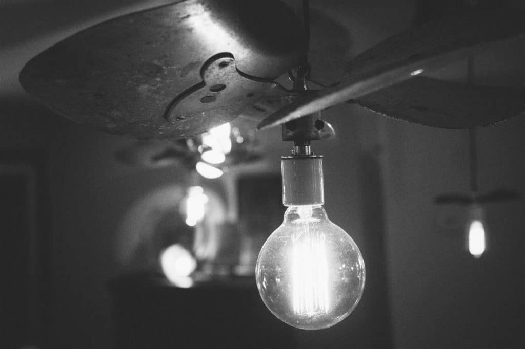 vintage light bulbs glowing softly in a moody black-and-white atmosphere, evoking warmth and nostalgia.