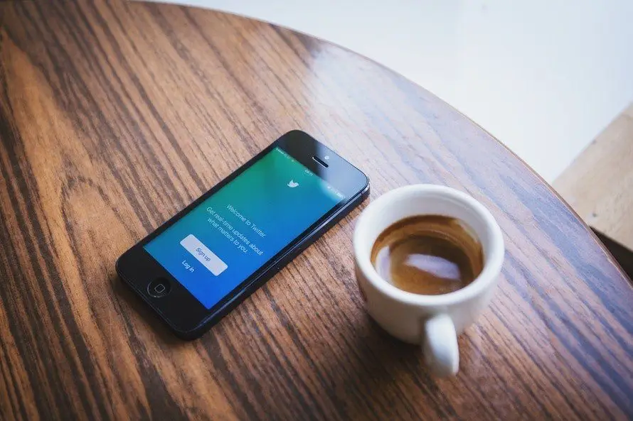 Coffee and smartphone create a tranquil moment blending social media with relaxation.