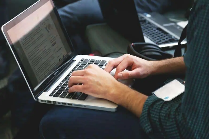 Looking For It Solutions For Your Business? 5 typing on a laptop in a collaborative workspace, enhancing business productivity and creativity.