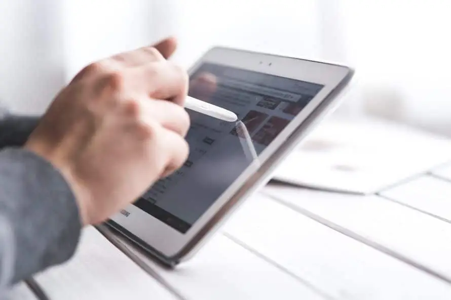 Why You Should See Technology As More Than A Business Expense 4 engaging with a tablet stylus, blending creativity and technology in a serene workspace.