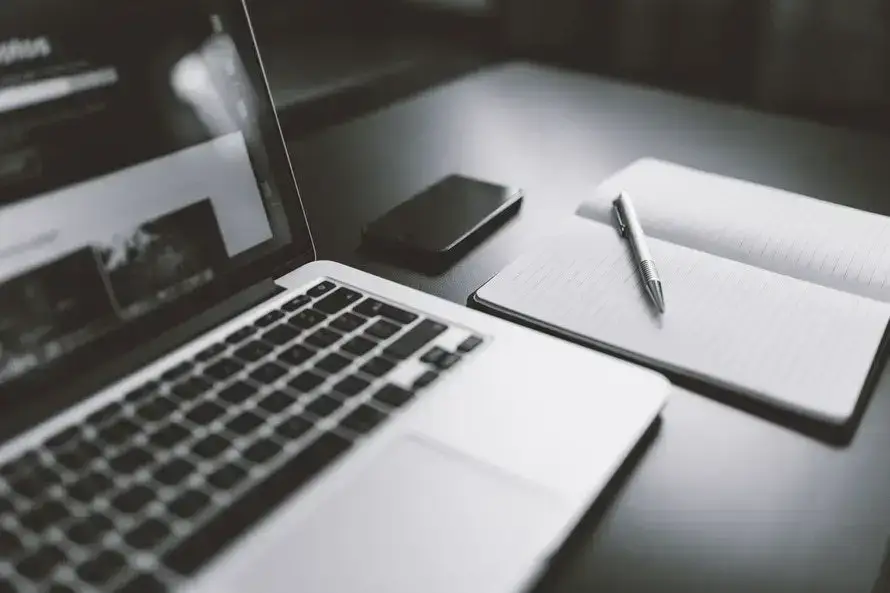 It Support Blog For New York Businesses 7 modern workspace featuring a laptop, smartphone, notebook, and pen for creative productivity.