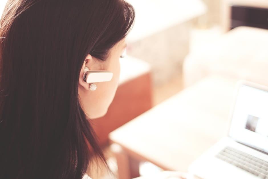 young woman in home office, focused on laptop during virtual meeting, balancing comfort and productivity.