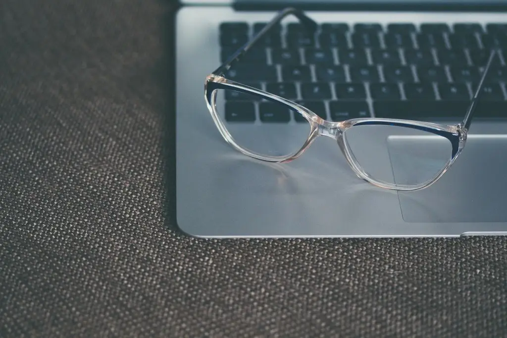 Sleek laptop with eyeglasses symbolizes clarity and productivity in a modern workspace.
