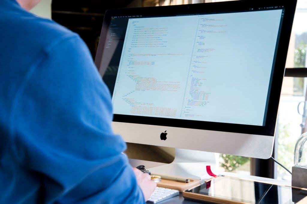 individual coding on imac, emphasizing password complexity for improved application security.