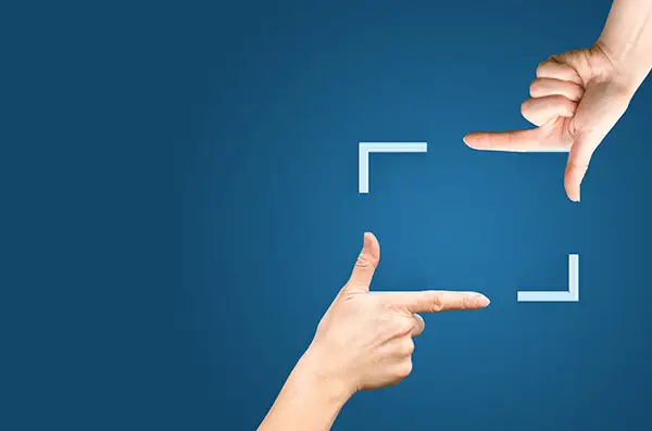 Faster, More Selective Screenshots - Computer Tip Of The Day 5 two hands framing a space against a blue background, symbolizing focus and creativity.