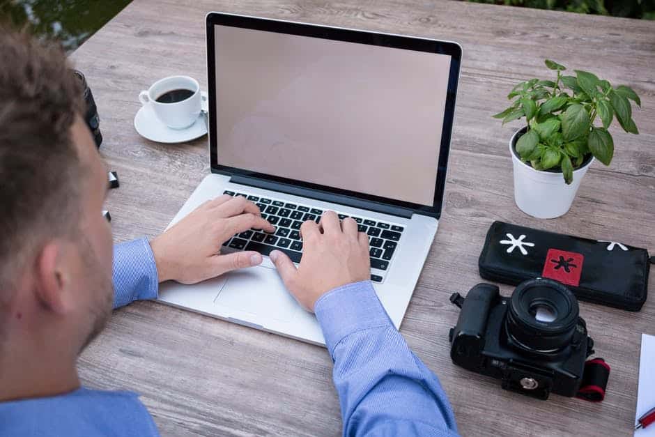 tranquil outdoor workspace with laptop, coffee, and plants, promoting creativity and relaxation.