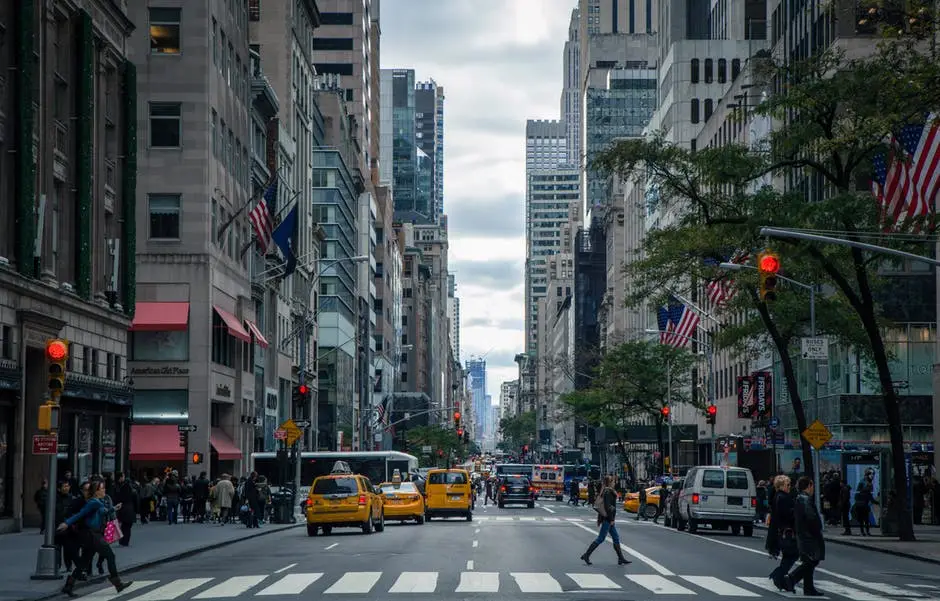 It Support In New York: The Benefits Of Outsourcing Your It Department 1 bustling city street with pedestrians and yellow taxis under an overcast sky, showcasing urban energy.