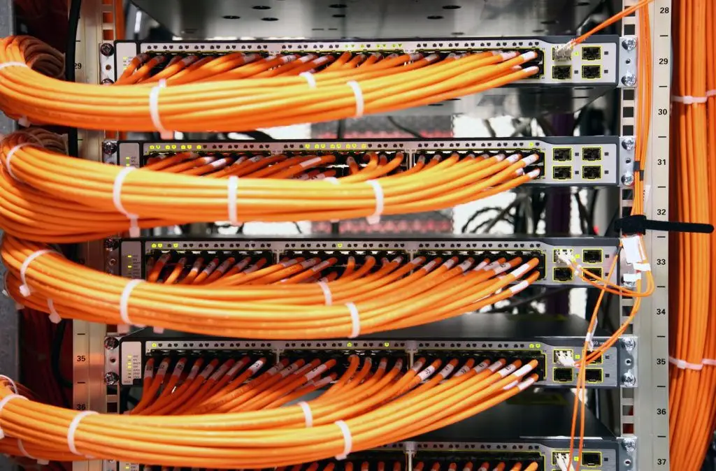 Network Cable Installation 6 vibrant orange cables neatly organized in a server rack, showcasing efficient network infrastructure management.
