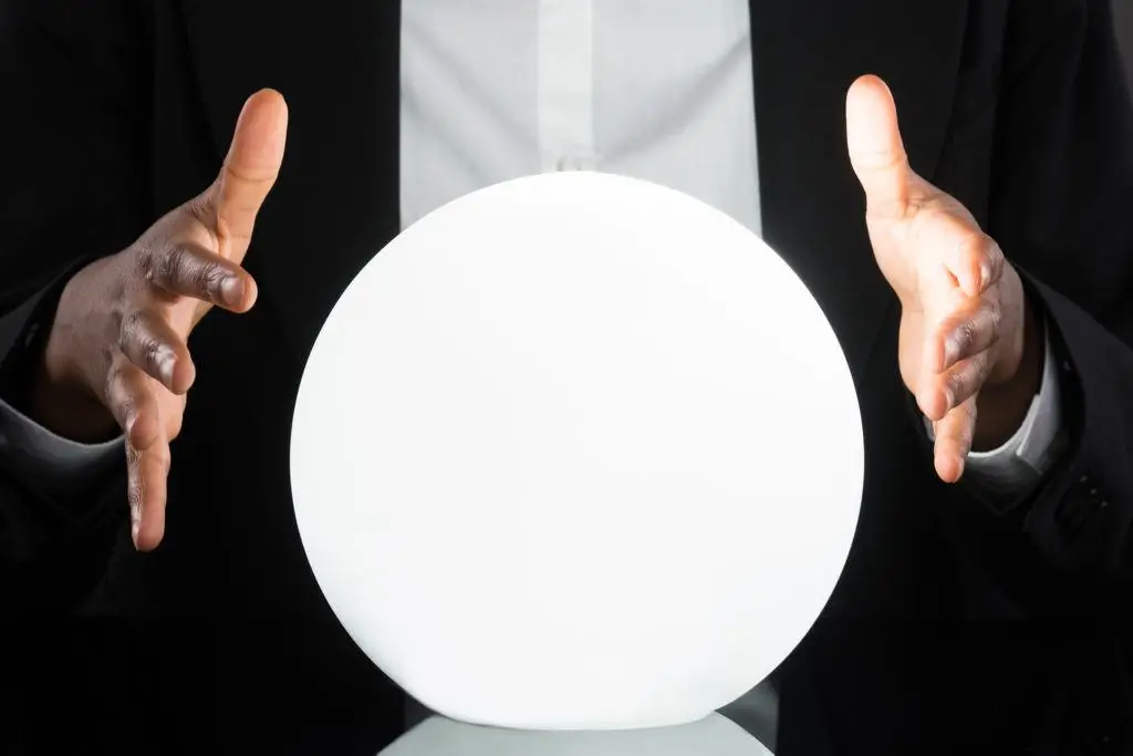 Elegant hands cradle a glowing crystal ball, blending mystique with scholarly insight.