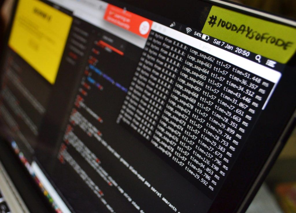 laptop screen shows terminal data with security tips against ransomware and a colorful sticky note.