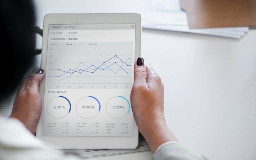 woman analyzing performance metrics on a sleek tablet in a professional setting.