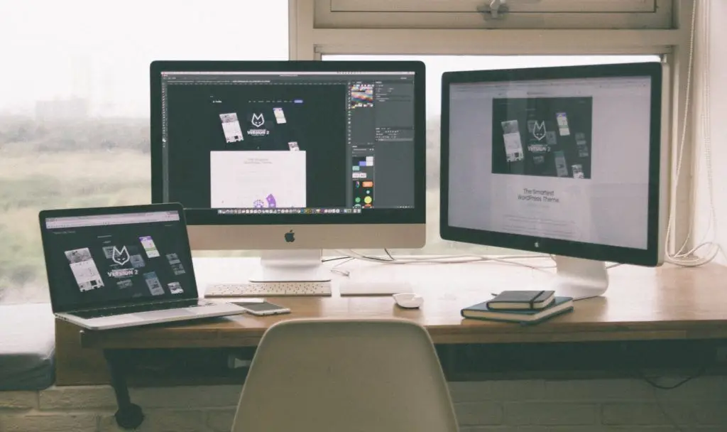 modern workspace with dual monitors and a laptop, highlighting a creative digital design setup.