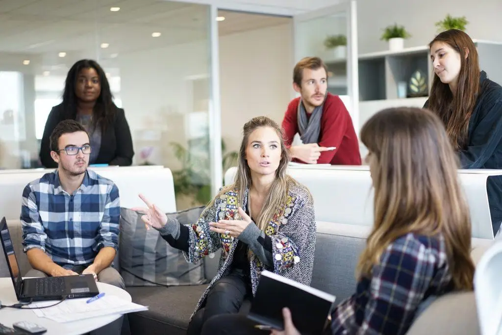 Should Your Company Move To Office 2019? Here'S What You Need To Know 1 engaged team brainstorming in a bright, modern office with lively discussions and open collaboration.