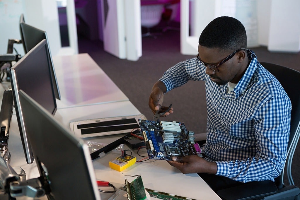 focused tech expert troubleshooting a motherboard in a sleek modern office workspace.