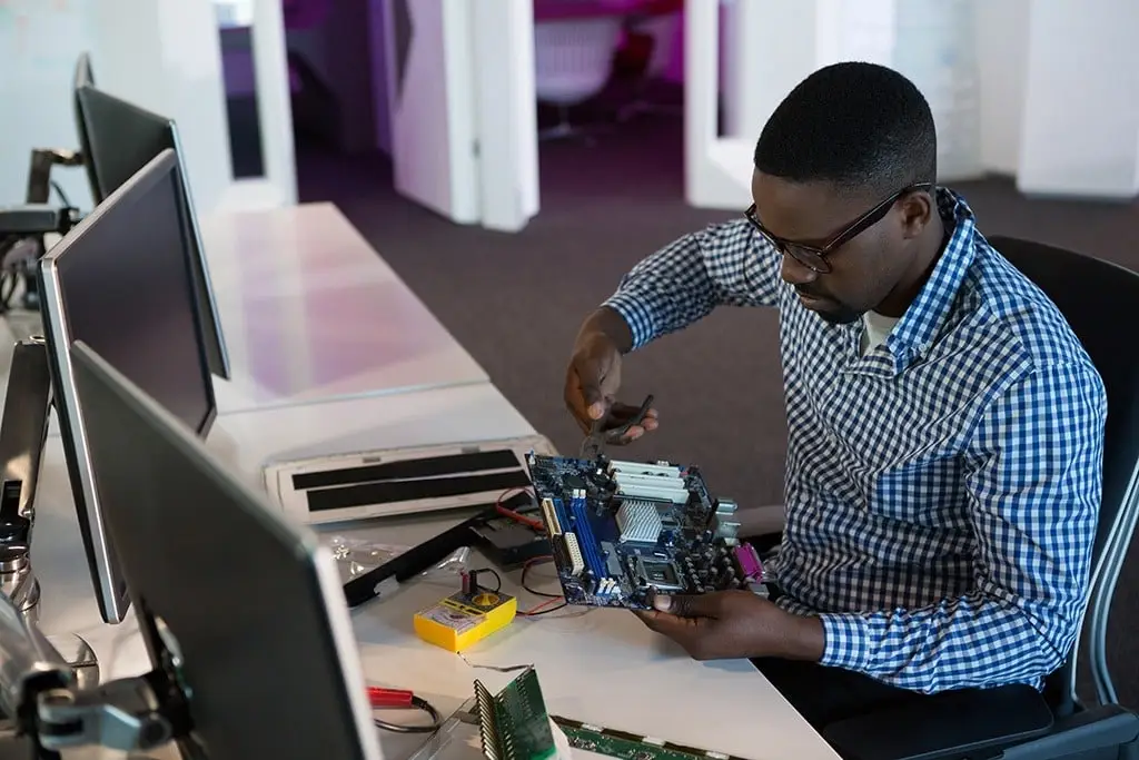 focused tech expert troubleshooting a motherboard in a sleek modern office workspace.