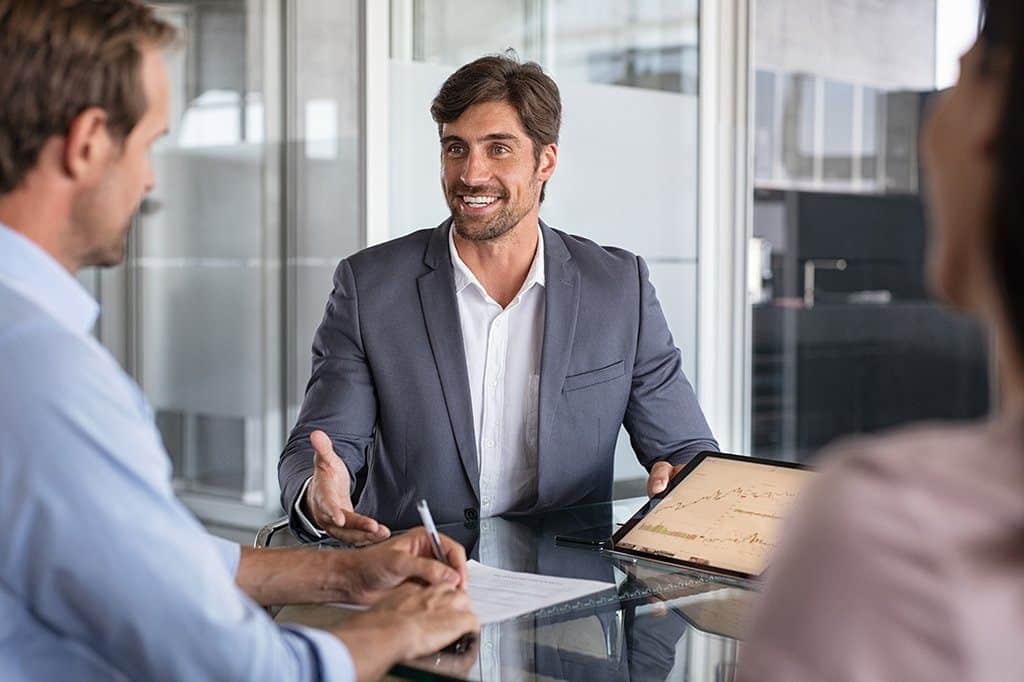 confident man presents insights in a modern office meeting with engaged colleagues.
