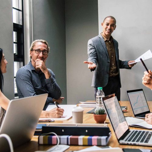 engaged team collaborates in a bright, modern meeting space with technology and dynamic discussions.