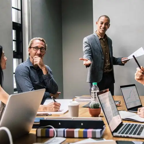 engaged team collaborates in a bright, modern meeting space with technology and dynamic discussions.