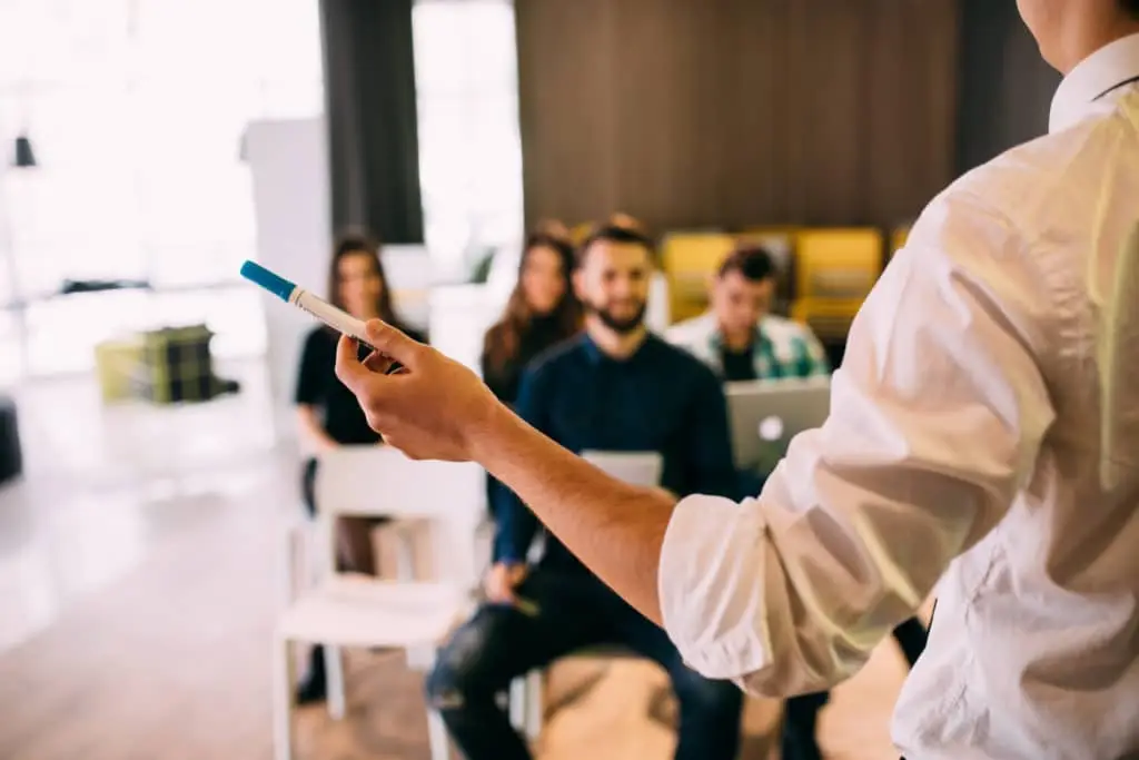 4 Steps To Make Cybersecurity Training Effective 1 dynamic workplace training with engaging presenter and attentive audience in modern collaborative setting.