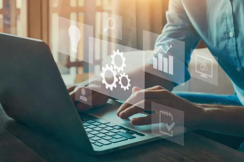 Your Business Can Benefit From Rice Prioritization Framework 5 businessman working on a laptop, surrounded by digital icons symbolizing automation and efficiency.