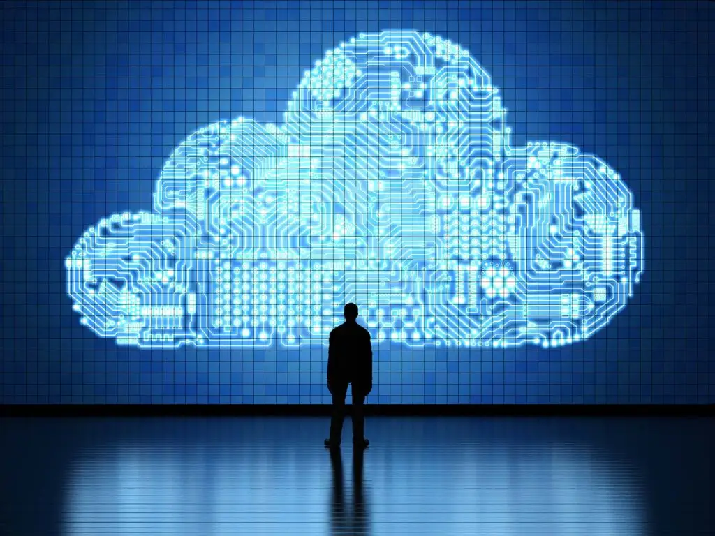 Cloud Platforms Are Deteriorating The Need For Onsite Computing 5 silhouetted figure reflects on luminous cloud technology and its impact on the digital future.