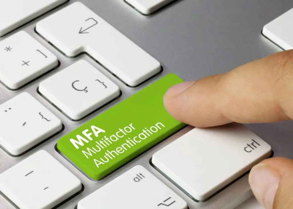 A finger poised over the green MFA key, emphasizing digital security through multifactor authentication.