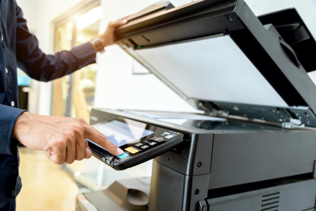 businessman operating a multifunction laser printer in a modern office setting.
