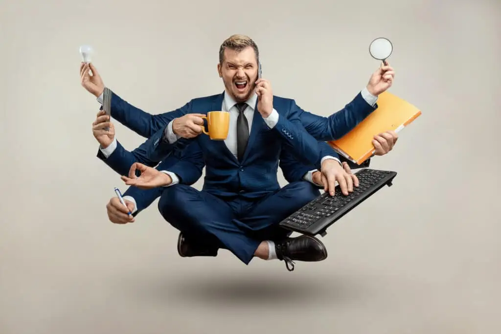 multitasking businessman in a suit, juggling a mug, magnifying glass, papers, and phone.