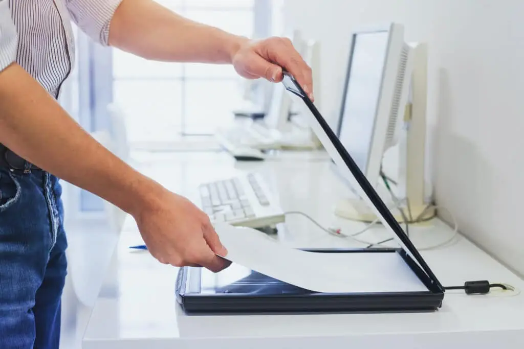 Tip Of The Week: Scan Picture Or Document To Pdf In Android 2 a man scans documents with a flatbed scanner in a modern office setting.