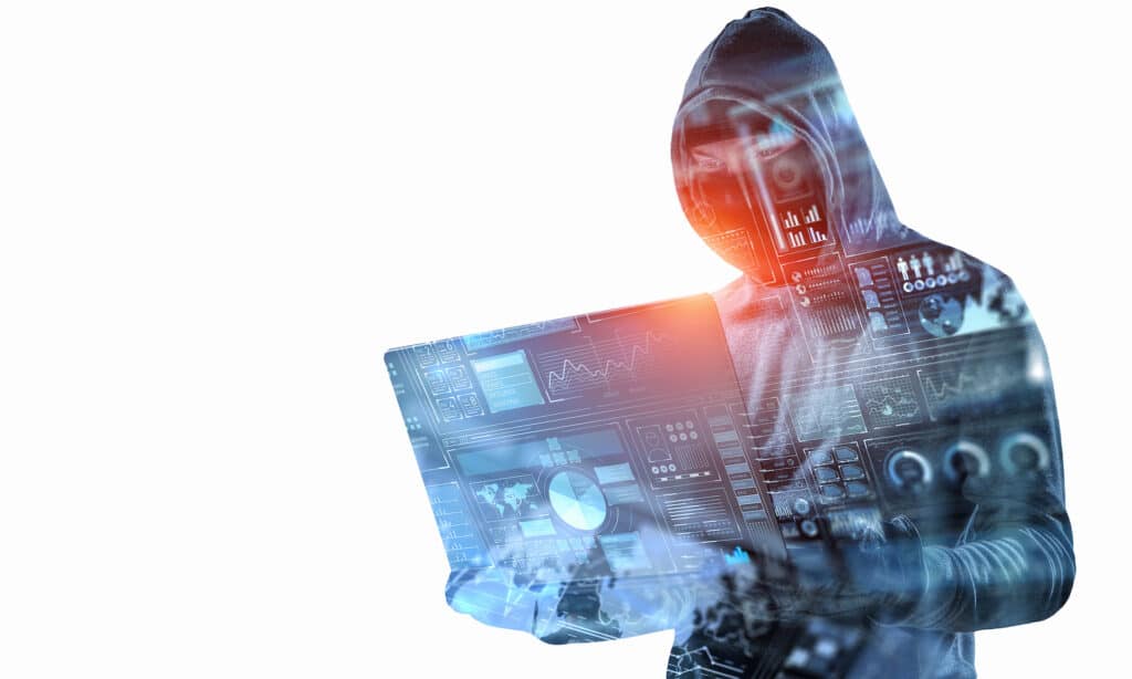hooded hacker at laptop illustrates the threats of cybercrime in a digital landscape.