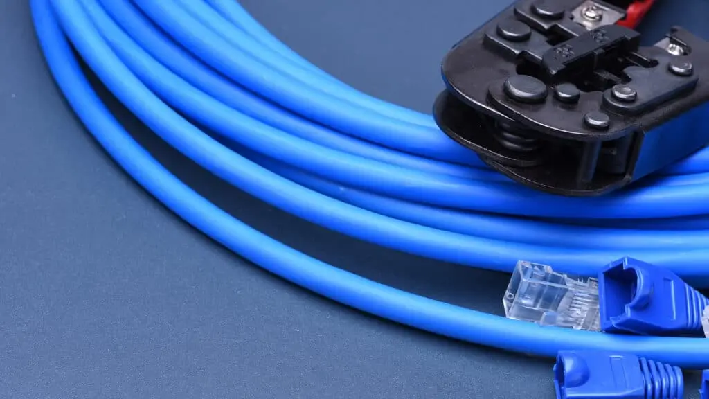 Blue Ethernet cables and a crimper tool for DIY networking installations and repairs.
